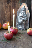 Candles in red apples in front of chocolate mould