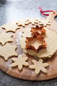 Cookie dough rolled out being cut out with a copper snowflake shaped cookie cutter