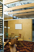 Glass table and designer chairs in front of sliding wooden element in elegant, architect-designed house