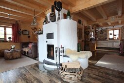 Masonry wood-burning stove in open-plan interior of wooden cabin