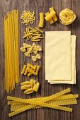Various types of pasta on a wooden surface