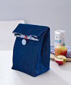 A denim lunch bag with button fastening