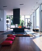 Hot-pink cushions and place settings on low table in front of open fireplace