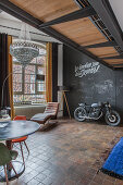 Motorbike in loft apartment with chalkboard wall and brown floor tiles