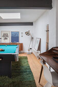 Pool table on green rug in masculine games room