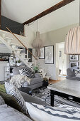 Grey sofa set in living room with self-supporting staircase in background