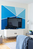 Wall painted in various shades of blue behind TV