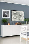 Vintage ornaments on floating sideboard on grey wall