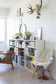 Fur blanket on chair next to shelves full of books and ornaments