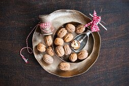 Walnuts with a nutcracker in a metal bowl
