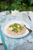 Pearl barley risotto (orzotto), served with yellow zucchini, broad beans and fresh thyme. Dish of Italian cuisine