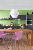 Dining table in kitchen with grey cabinets, green wall and stucco ceiling