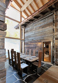 Long set dining table between two mountain huts incorporated into architect-designed house