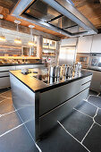 Modern stainless steel kitchen with slate floor in wooden house