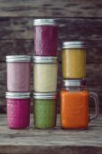 Glass jars of different coloured smoothies