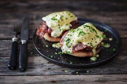 Eggs Benedict auf dunklem Teller