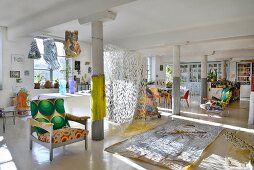 Columns and colourful eclectic furnishings in loft apartment