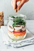 Veganer Schichtsalat im Glas mit Weisskohl, Karotten, Radieschen, Champignons und Spinat