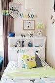 Bed with pillows and a shelf on the headboard in the boy's room