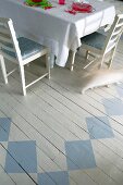 Set table on white wooden floor painted with geometric pattern