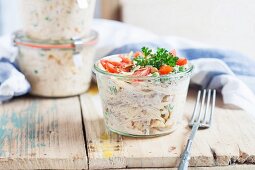 A vegetarian pasta salad with peas and sriracha sauce in a glass jar