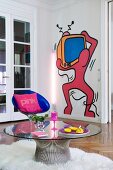 Pop-art mural on wall behind round glass table