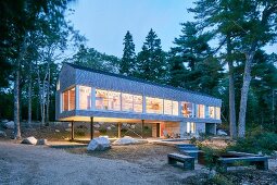 Modern, architect-designed house on stilts at twilight