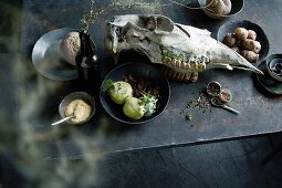 Beetroot, kohlrabi, celery cream, spices and an animal skull on a table