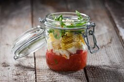 Fusilli with tomato sauce, mozzarella and rocket in a glass jar