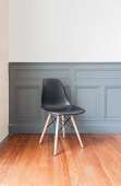 Black classic chair in front of dove grey wainscoting