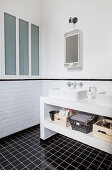 Twin sinks on washstand in black and white bathroom