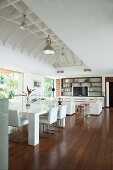 White designer furniture in open-plan living area of beach house