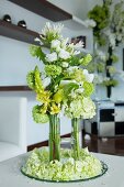 Flower arrangement in glass vases on plate covered in flowers