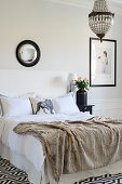 Fellplaid auf dem Bett im eleganten Schlafzimmer in Schwarz-Weiß