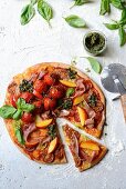 Spelt pizza with tomatoes, ham, nectarines and kale pesto