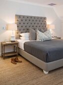 Sisal rug and grey button-tufted headboard in bedroom