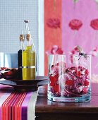Radicchio mit Rosenblättern in Glasschale und Olivenöl auf Holztisch