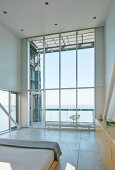 High-ceilinged room with panoramic window and sea view