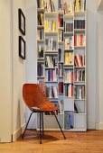 White bookcase and retro chair in reading corner in period apartment
