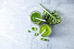 An apple and spinach smoothie and an apple and kale smoothie with basil