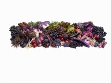 Purple fruit and vegetables in front of a white background