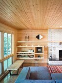 Lounge area with open-fronted shelves next to white brick chimney breast