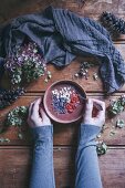 Woman eating chocolate smoothie bowl with Brazil nuts, goji berries and cacao nibs
