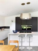 Counter and bar stools in minimalist designer kitchen