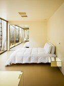 Minimalistisches Schlafzimmer mit verspiegeltem Einbauschrank im Hintergrund
