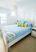 Double bed with colorful pillows in bright guest room