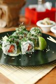 Sushi rolls with salmon, fresh cheese and herbs