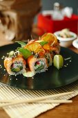 Sushi rolls with salmon, avocado, fresh cheese and herbs
