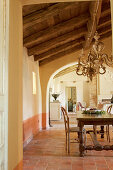 Long wooden table in dining room with archway leading into living room