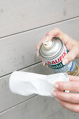 Spraying crumpled drinks can with gold paint